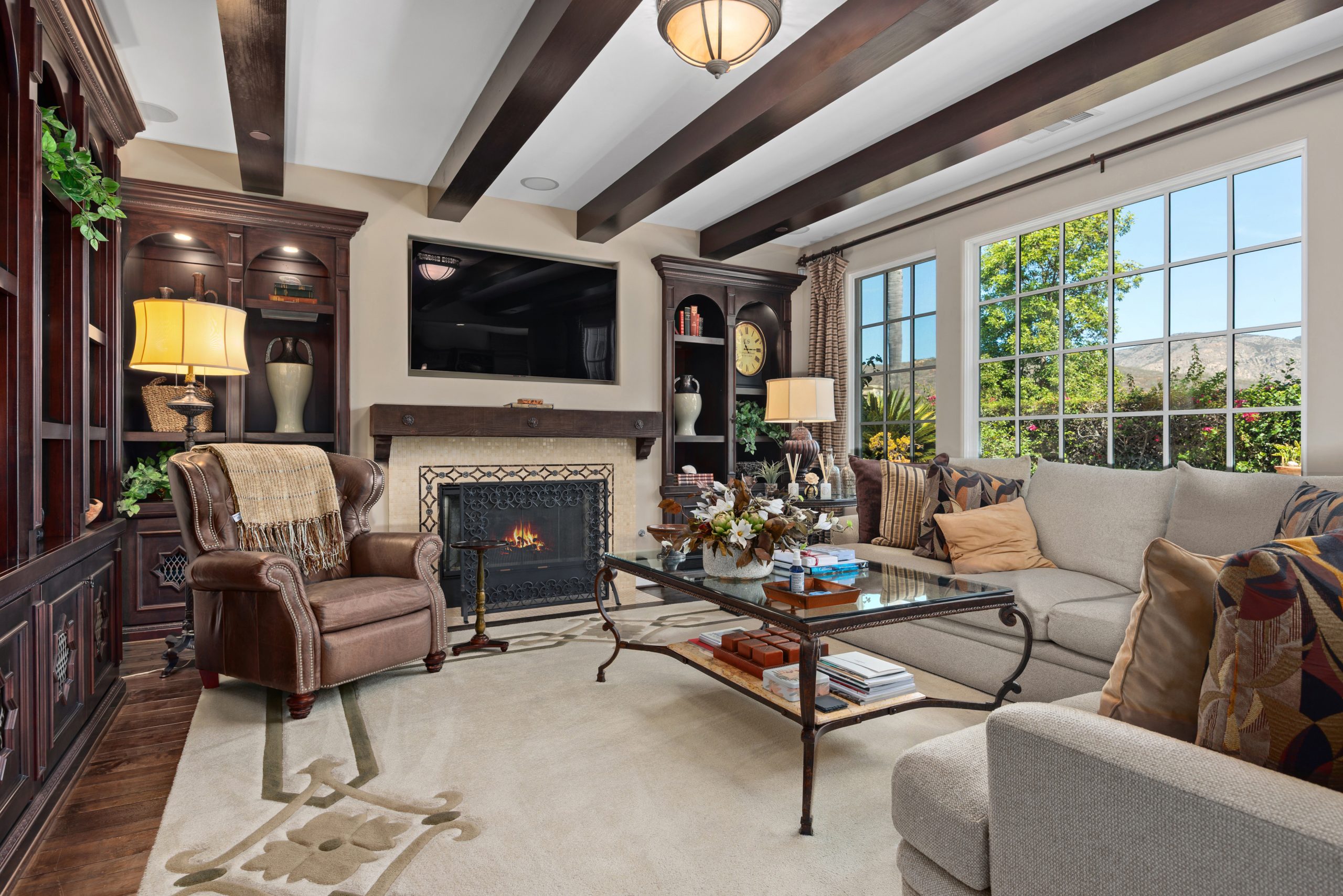 Elegant family room with fireplace and views in Rancho Santa Fe luxury home